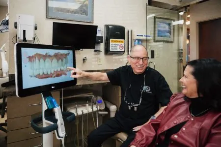 Photo of cosmetic dentist Dr. Fred Peck showing a smile design to a patient.