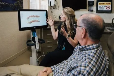 Photo of Dr. Frew looking at a smile design with a patient.