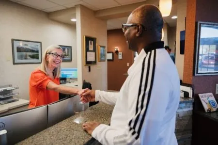 Photo of the office manager greeting a patient.